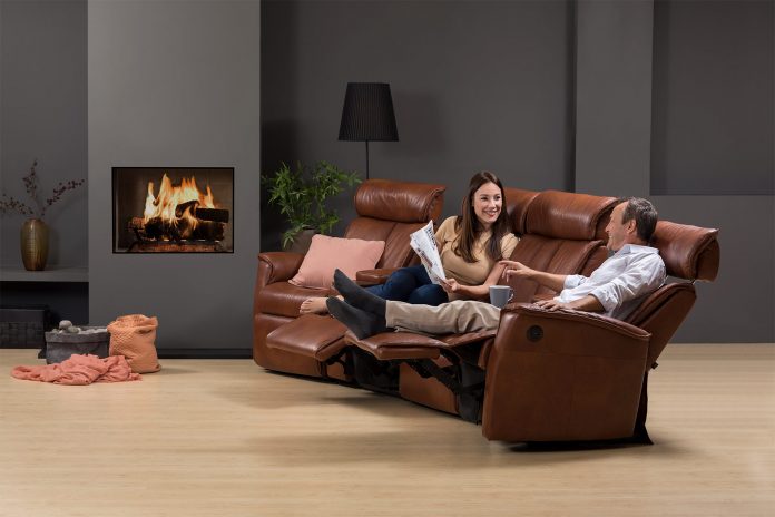 A person sitting in a living room Description automatically generated