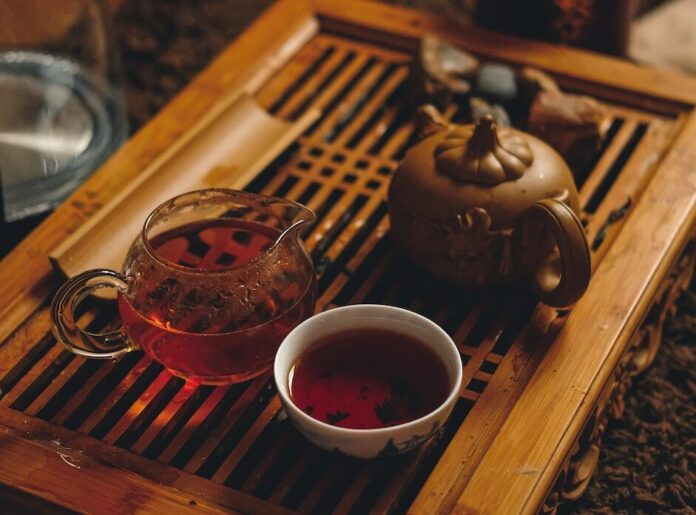selective focus photography of cup of bowl beside brown teapot