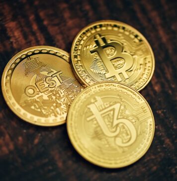 Everything You Need to Know about Bitcoin Betting three gold bitcoins sitting on top of a wooden table