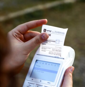 Simplify Your Invoicing Process with Zintego’s Free Invoice Generator, Invoice Templates, and Receipt Maker Software a person holding a cell phone and a receipt