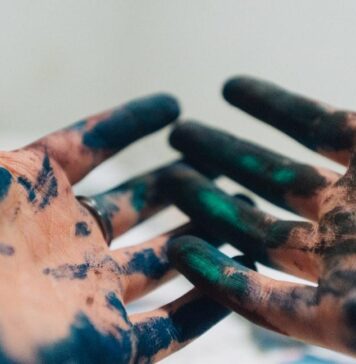 Will painting my kitchen cabinets bring up or down my home’s value? person hand with green and blue paint